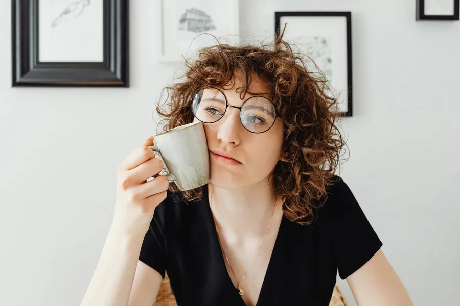 frau mit tasse in der hand denkt nach