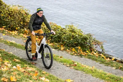 Mann fährt auf e-bike einen weg entlang