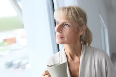 frau mit tasse in der hand denkt nach