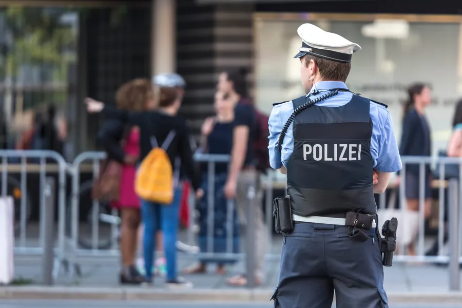 polizist steht vor einer absperrung