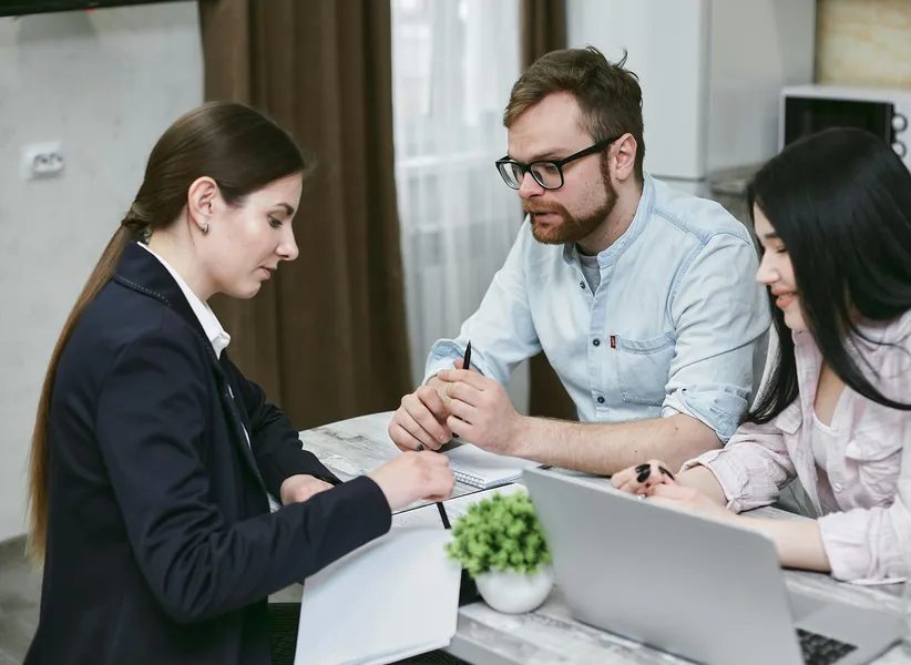 drei personen besprechen informationen von einem blatt