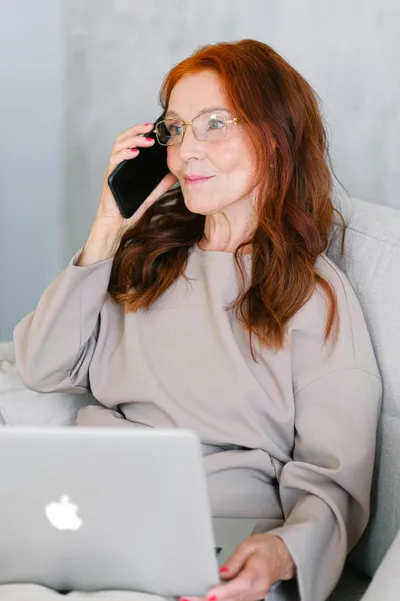 frau telefoniert und hat laptop auf dem schoss