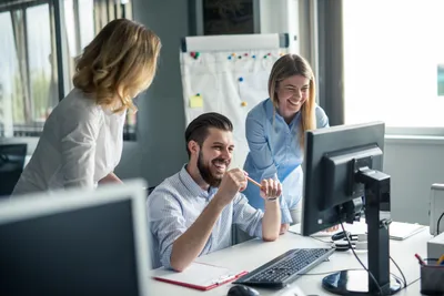 zwei frauen beobachten die arbeit eines kollegen